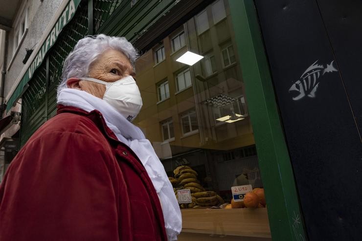 Unha muller protexida con máscara diríxese á entrada dun establecemento alimenticio na Coruña / M. Dylan - Arquivo