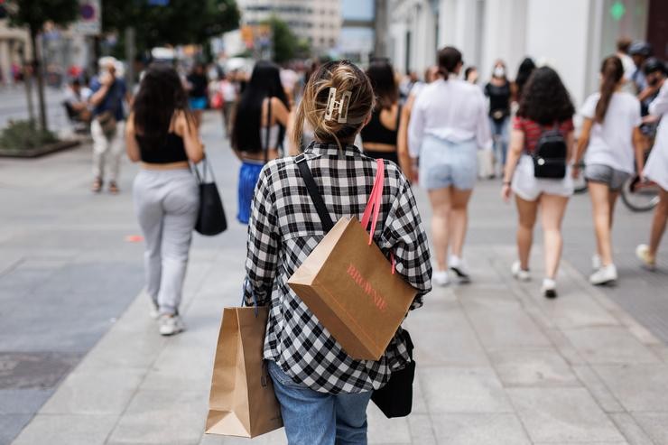 Unha muller pasea con bolsas de firmas de moda pola Gran Vía/Alejandro Martínez Vélez 