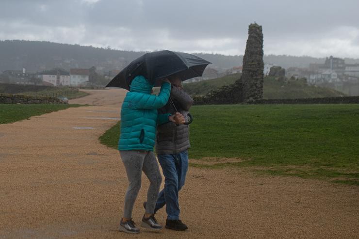 Dúas persoas protéxense da choiva cun paraugas, na praia da Lanzada, a 5 de novembro de 2023, no Grove, Pontevedra, Galicia (España). A borrasca Domingos deixou en toda Galicia un total de 1.166 incidencias. En Pontevedra, foron 438, l. Elena Fernández - Europa Press / Europa Press