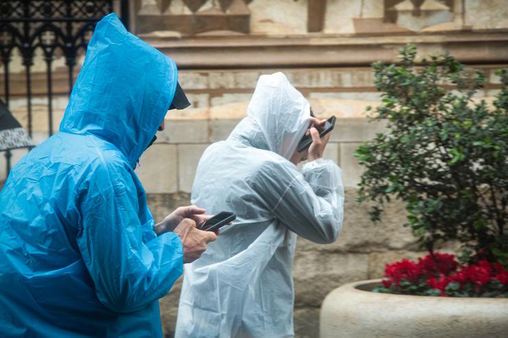 Dúas persoas protéxense da choiva cun impermeable. María José López - Europa Press 