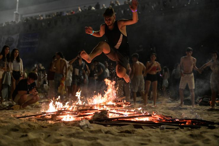 Unha persoa salta unha fogueira durante a Noite de San Xoán, na praia de Riazor / M. Dylan - Europa Press 