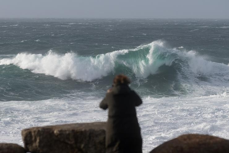 Unha persoa grava a ondada na zona do Acuarium Finisterrae, na Coruña, Galicia 