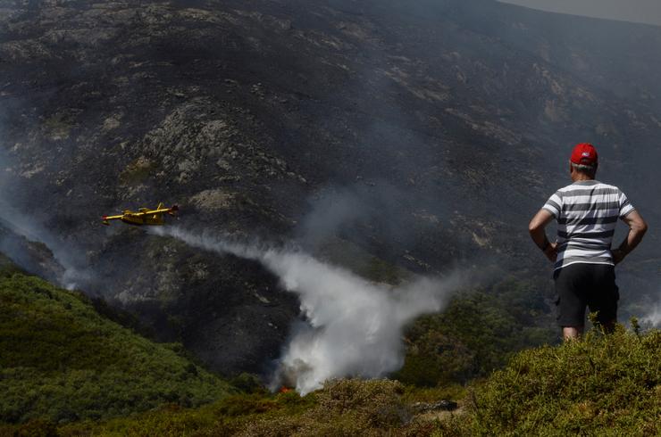 Un veciño de Senderiz en Lobeira observa un hidroavión traballar no incendio forestal na Serra do Leboreiro, no parque natural de Baixa Limia e Serra do Xurés / Rosa Veiga - Europa Press - Arquivo  / Europa Press