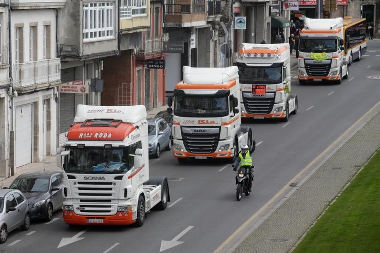 Un motorista apoia aos camións que pasan pola Rolda da Muralla, nunha marcha lenta que saíu desde o polígono das Gándaras para pasar por varias localizacións do centro da cidade, durante o noveno día de paro nacional de transportistas 