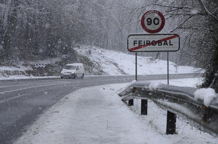 Un coche pasa por unha estrada cuberta de neve, a 18 de xaneiro de 2023, en Ourense 