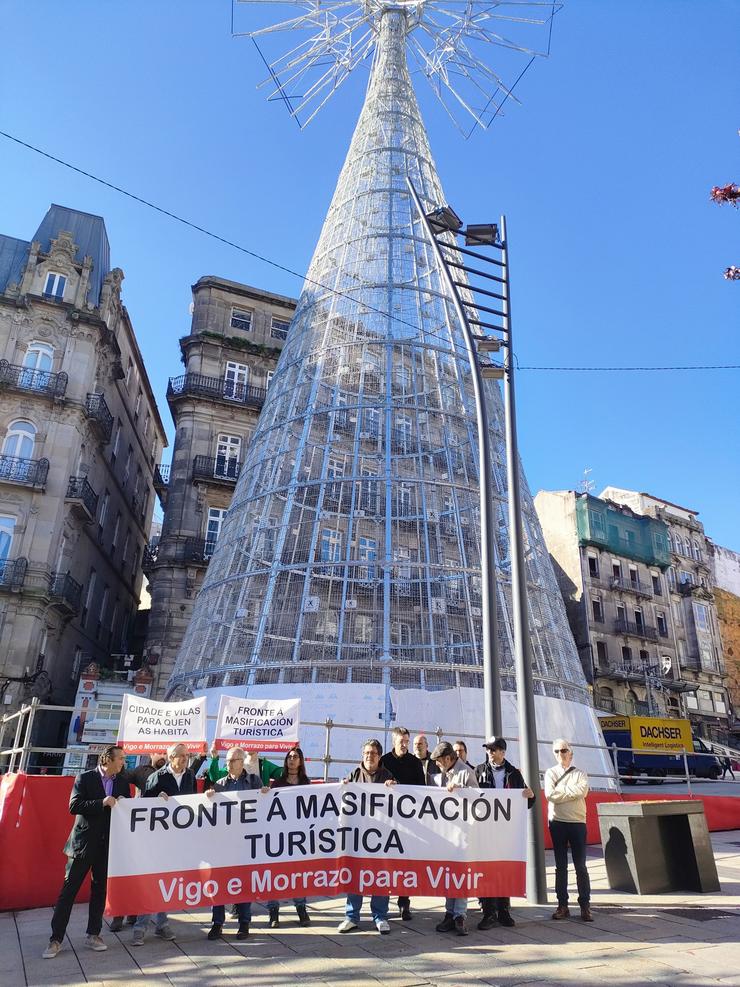 Integrantes da Plataforma contra a Masificación Turística Vigo-O Morrazo, fronte á árbore xigante de Nadal instalado no centro da cidade olívica. / Europa Press