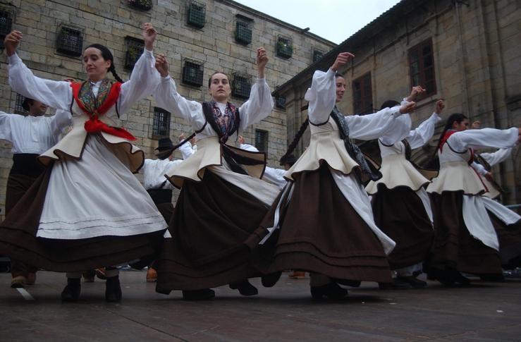 Agrupación folclórica galega vestida co traxe tradicional galego bailando 