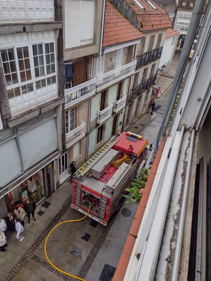 Bombeiros do parque comarcal de Boiro extinguen as chamas nunha terraza exterior dun edificio en Rianxo.. CONSORCIO CONTRA INCENDIOS E SALVAMENTO A Coruña 