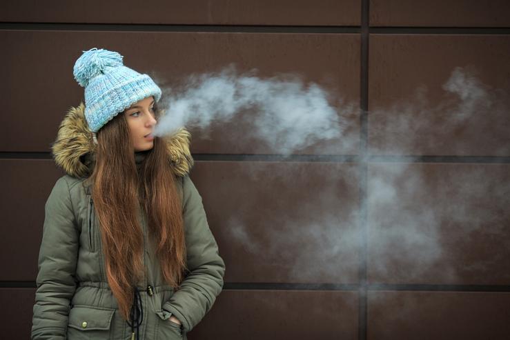 Moza mozo vapeando cun vaper ou cigarro electrónico 