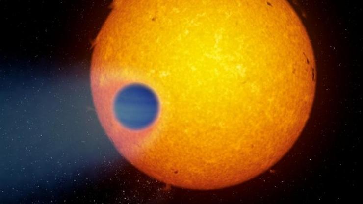 Representación artística do exoplaneta xigante WASP-69b que perde a súa atmósfera en forma de cola, e que podería ter auga 