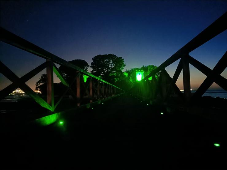 Castelo de San Antón iluminado da cor verde da ELA 