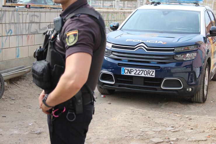 Imaxe dun axente e un coche patrulla da Policía Nacional.. POLICÍA NACIONAL 