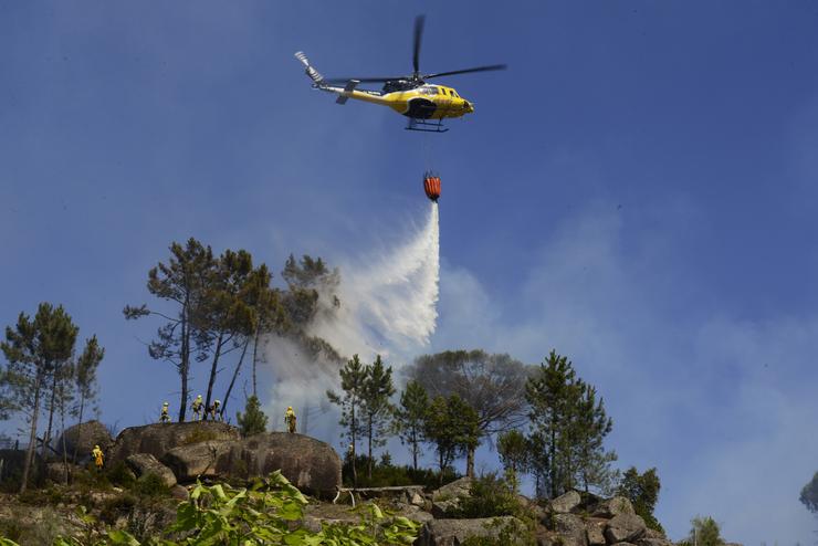 Arquivo - Un helicóptero arroxa auga sobre un incendio forestal, a 28 de xullo de 2021, na parroquia de Santa Mariña do Monte, Ourense, Galicia (España). Un total de seis avións e dous helicópteros traballan para controlar este incendio que actualmente. Rosa Veiga - Europa Press - Arquivo 