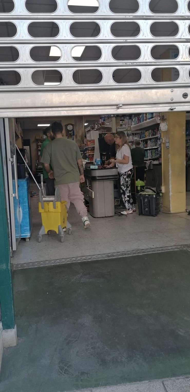 Traballadores limpan a zona na que se produciu o accidente nun supermercado en Carballo (A Coruña) 