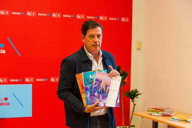 O líder do PSdeG, Xosé Ramón Gómez Besteiro, mostra libros de texto e un tiquet de compra.. PSDEG 