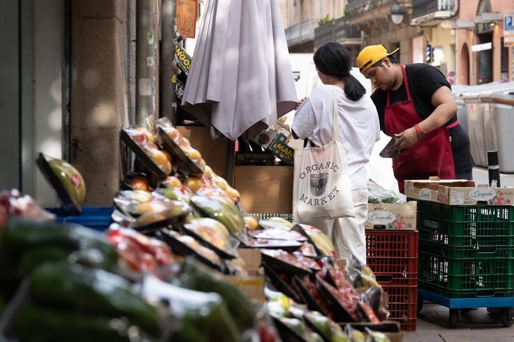 Varias froitas expostas no exterior dunha frutería rexentada por un traballador autónomo