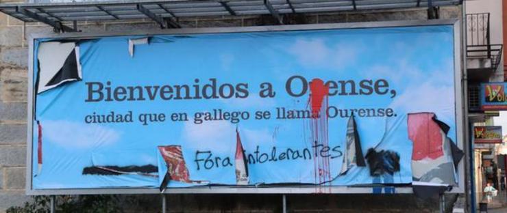 Valado publicitario de Hablemos Español co topónimo Ourense deturpado 